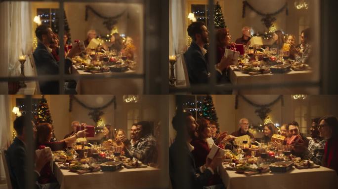 雪屋窗户镜头:不同的家庭交换圣诞礼物庆祝圣诞节。美丽的老人和年轻的亲戚兴奋地收到礼物。在家共进节日晚