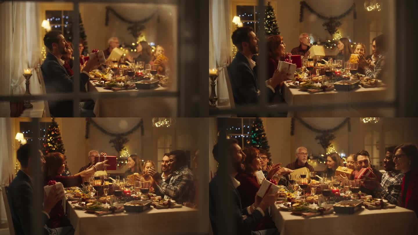 雪屋窗户镜头:不同的家庭交换圣诞礼物庆祝圣诞节。美丽的老人和年轻的亲戚兴奋地收到礼物。在家共进节日晚