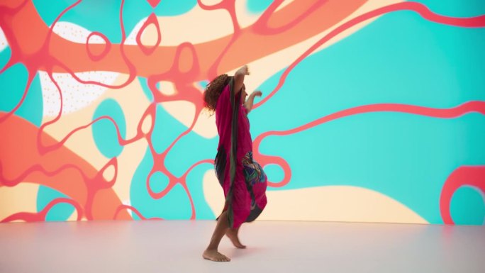 一位才华横溢的黑人女艺术家在抽象艺术背景下的工作室里展示舞蹈动作的肖像。非洲妇女用她创新的现代舞套路