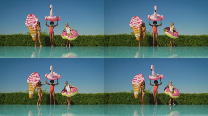穿着泳装的多民族年轻女友在泳池边一起享受暑假的慢镜头。在阳光明媚的日子里，带着彩色充气娃娃跳舞的漂亮