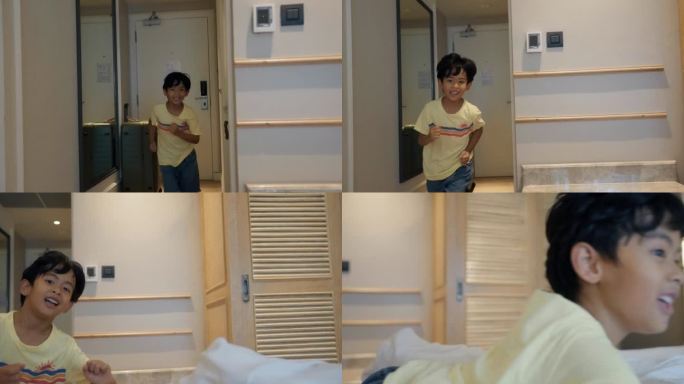 孩子在旅馆的房间里。一个带着行李箱的男孩在旅馆房间的床上跳来跳去。