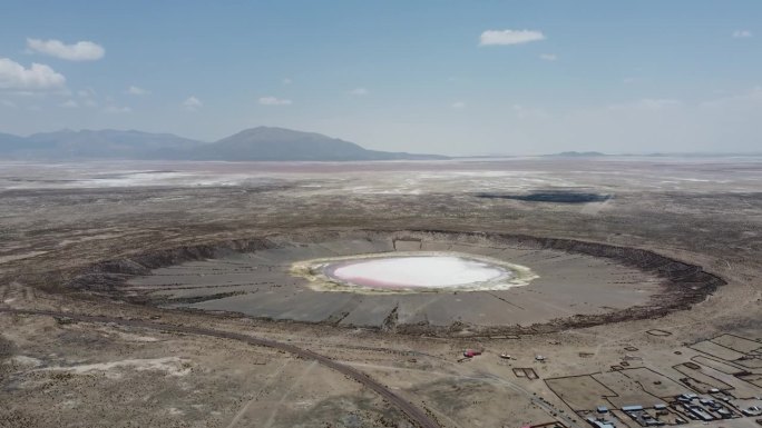相机环绕奇帕亚流星撞击坑玻利维亚与白色和粉红色的水在火山口航拍视频