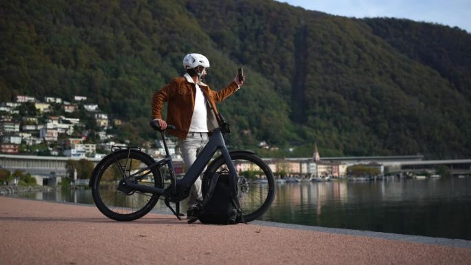 城市骑行，电动自行车通勤者捕捉到湖边的景色