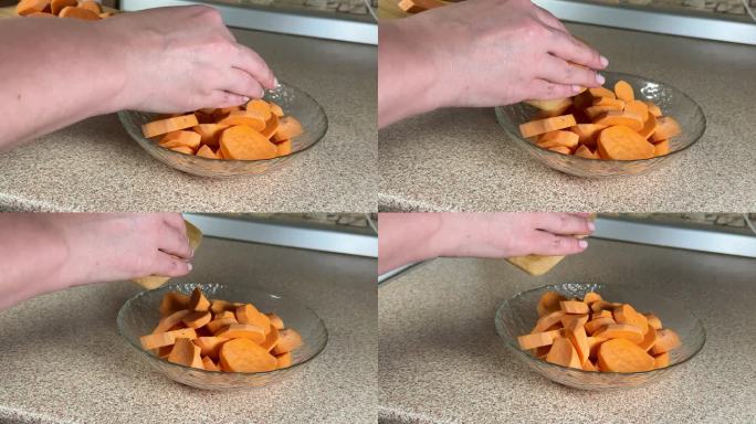 一个女孩正在做一个橙色的红薯，她把一块木板上的蔬菜倒进盘子里