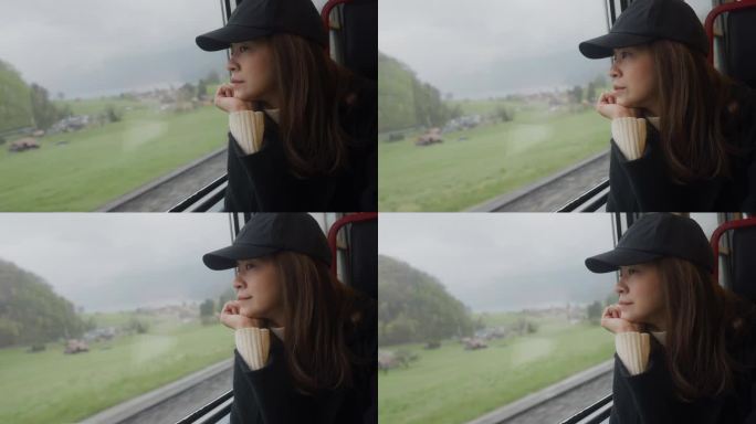 美丽的女游客坐在火车的窗边，透过窗户看风景