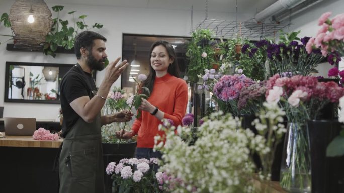 一位高兴的客户从小型商业花店买了一束花