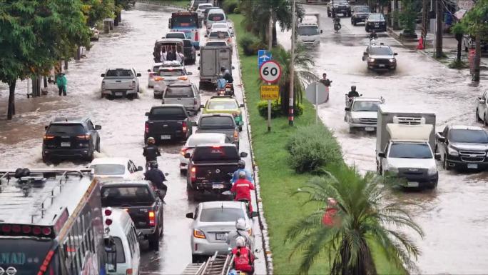 在被水淹没的道路上行驶的车辆。