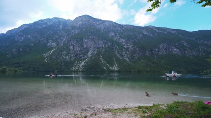 不知名的游客在风景秀丽的斯洛文尼亚博希尼湖上划皮划艇