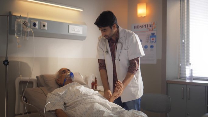 在明亮的现代医院里，一个年轻的实习医生检查他的老年病人的慢镜头。男护士检查手术成功后静息住院病人的心
