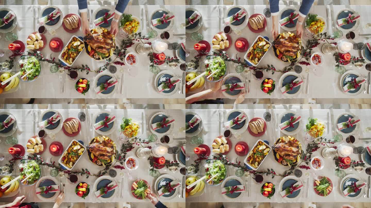 高雅装饰的圣诞宴会桌烤火鸡，蔬菜配菜，烤土豆，甜点。从上往下看，人们把盘子放在家里的餐桌上