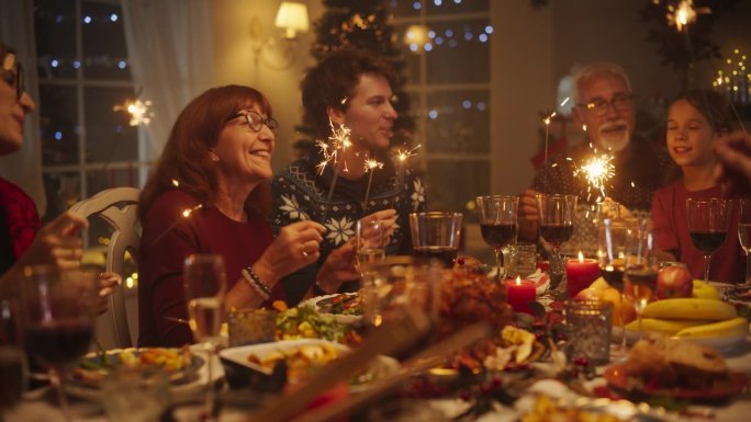 在家里与多元文化的亲人一起庆祝圣诞夜，享受火鸡晚餐。老人和年轻人一起唱节日歌曲庆祝节日