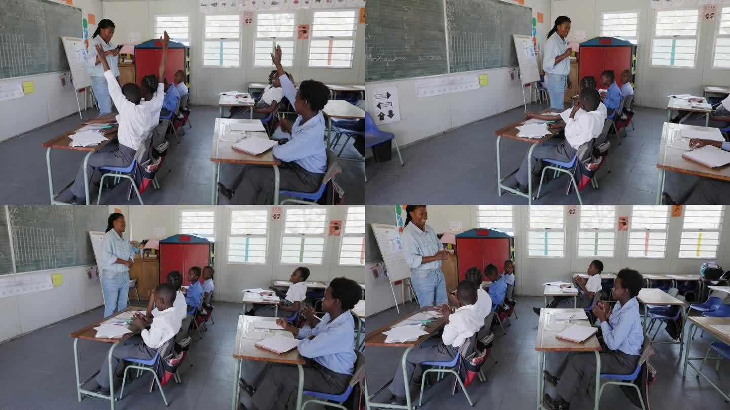 特写镜头。非洲黑人女教师站在黑板前，在非洲的一间教室里给孩子们上课