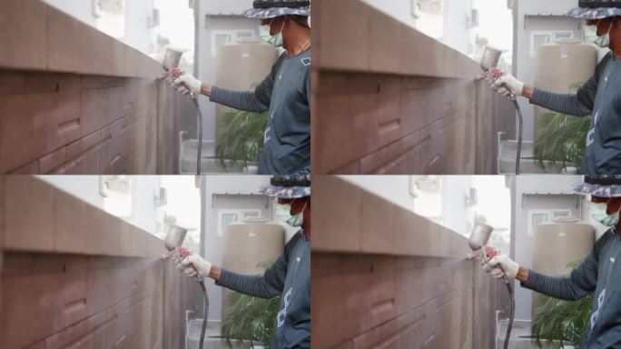亚洲的画家用工具油漆粉刷室外的砖墙。