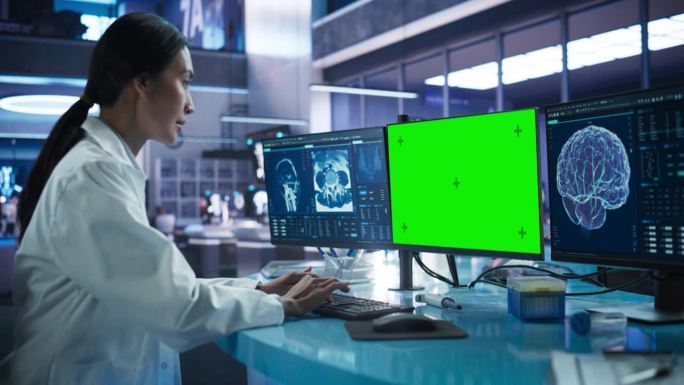 医院研究实验室:亚洲女医学家使用电脑绿屏色度展示。神经学家分析CT扫描，为脑损伤患者找到治疗方法。