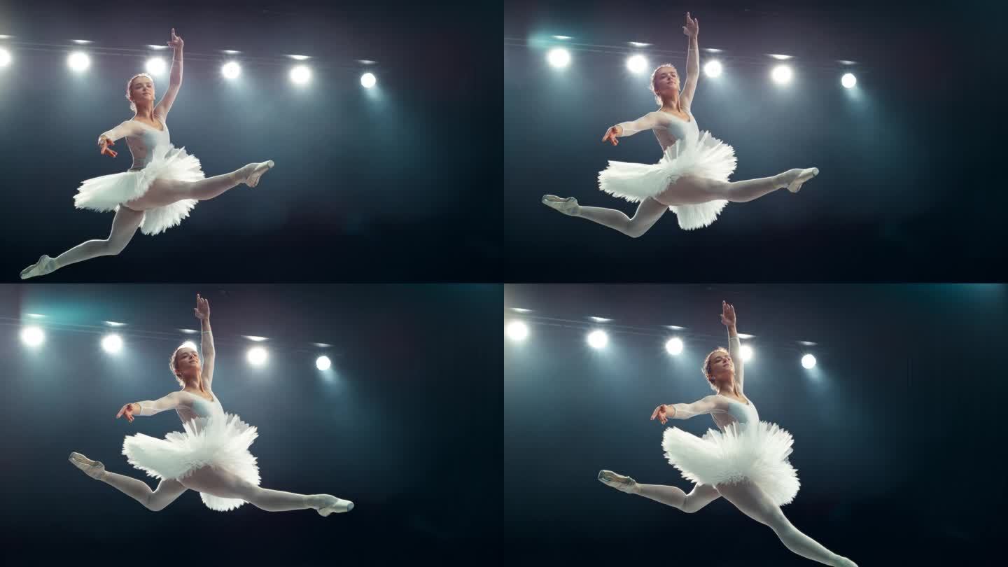优雅的芭蕾舞演员在表演中表演了一个有力的劈叉跳跃。年轻女性在黑暗的房间里练习惊人的漂亮衣服。电影超级