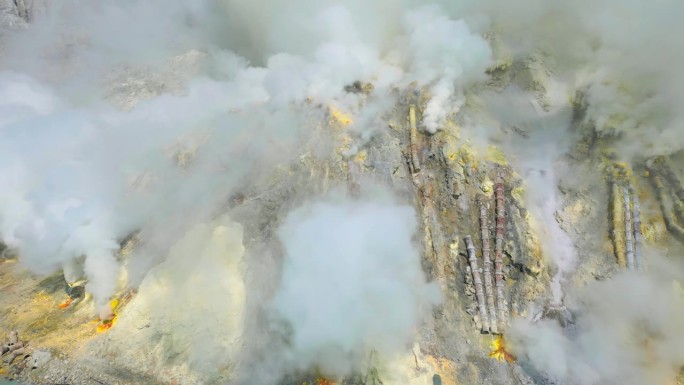 印度尼西亚东爪哇，卡瓦伊真活火山火山口硫磺矿中的有毒火山气体，火山火山口内有绿松石湖。空中无人机观看