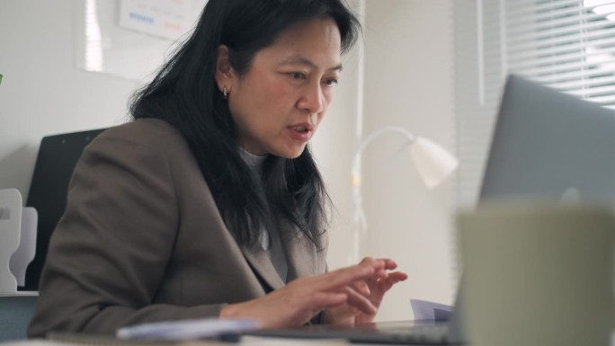 亚洲商务女性，在现代办公室用笔记本电脑进行营销计划和视频会议