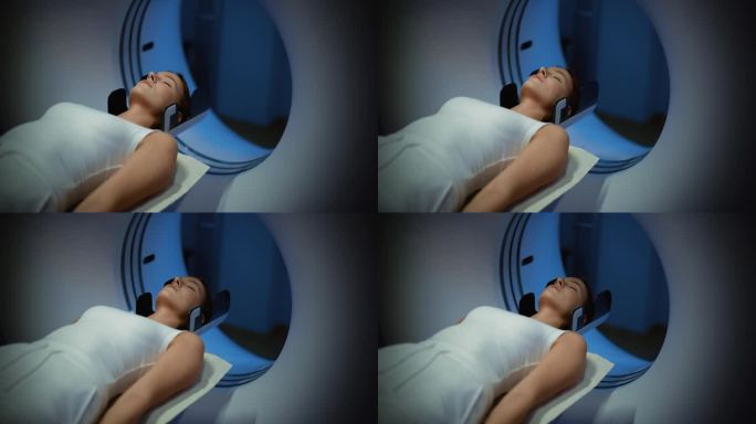 在拥有高科技设备的医学实验室:一位躺在CT或MRI扫描上的女性病人的特写肖像，当机器扫描她的身体和大