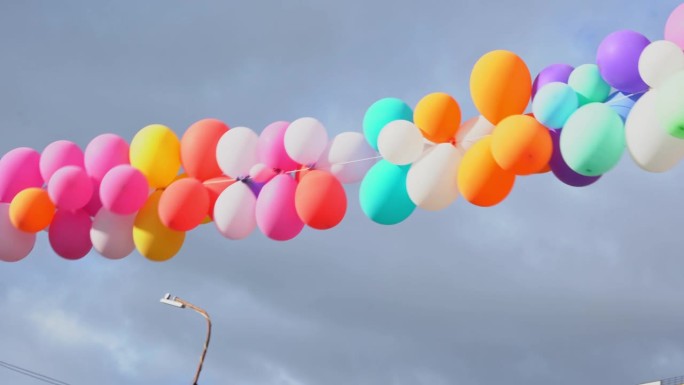 一束长长的彩色气球悬挂在空中