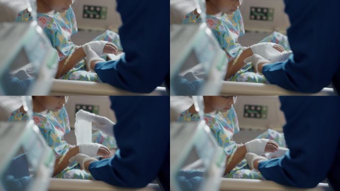 护士正在为一个小孩解开绷带，取出静脉输液管。