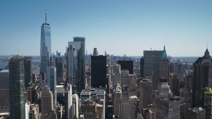纽约曼哈顿下城的鸟瞰图。全景市区镜头从直升机在一个阳光明媚的日子。现代建筑，办公大楼和历史悠久的摩天
