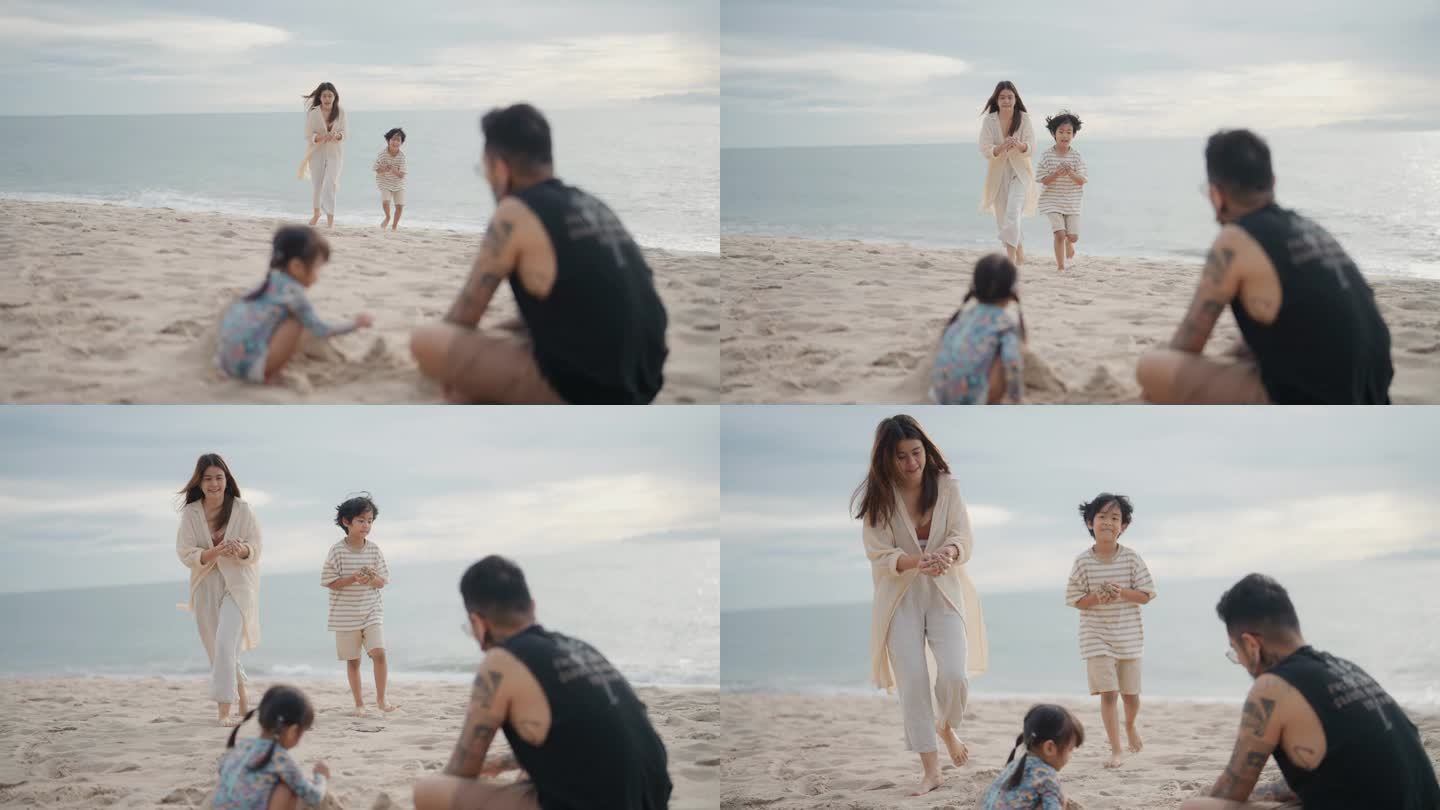 亚洲幸福的家庭在日落时在海滩上玩沙堡。