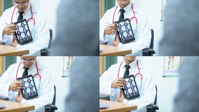 医生用电子平板电脑与病人讨论脑部扫描