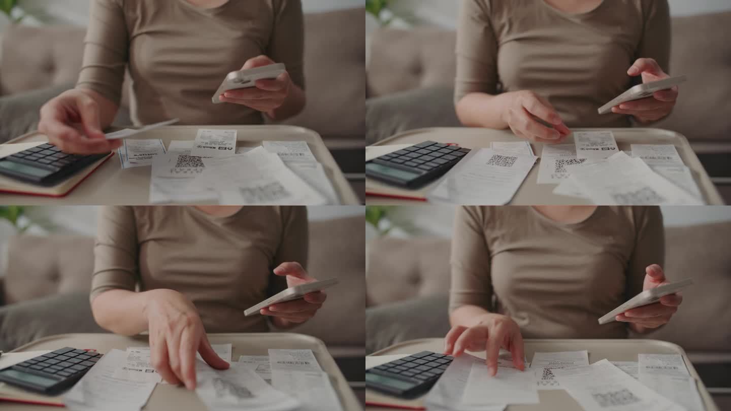 一名妇女在手机上计算她的预算和支出的收据，女性的手在计算每月的支出