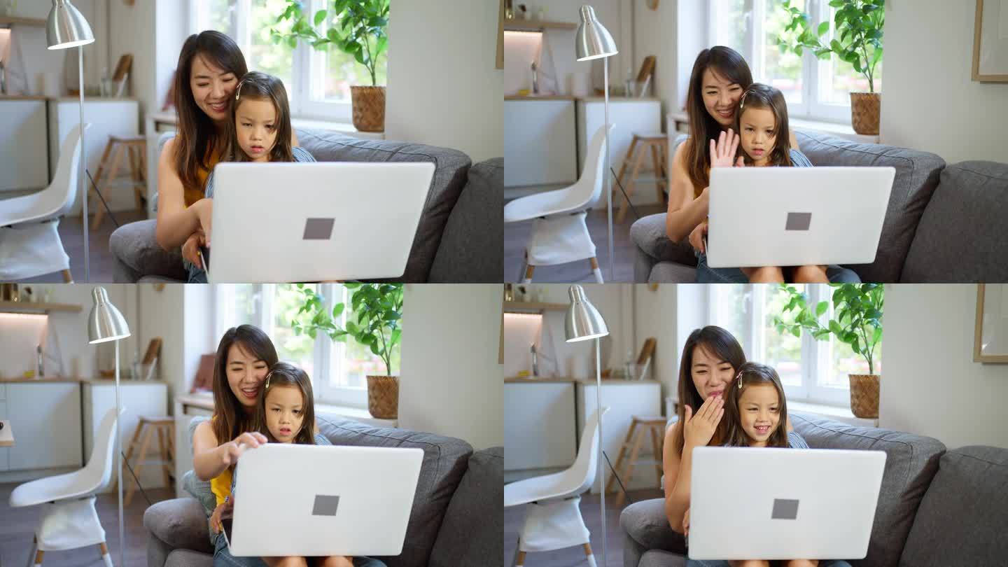 日本母女在笔记本电脑上一起看动画片