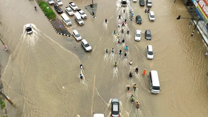 在被水淹没的道路上行驶的交通车辆鸟瞰图。