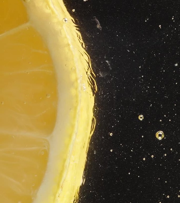 玻璃盘子上的柠檬片，从下面看，周围滴着汁液和溶解的蜂蜜。微距镜头。垂直视频。