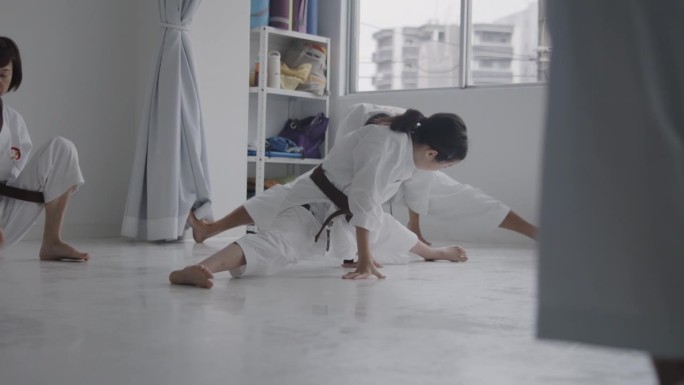 日本女孩在空手道课前做伸展运动
