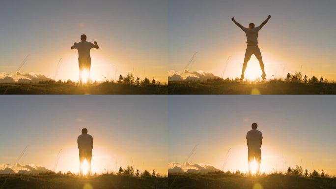 镜头光晕:日出时，一个年轻人在长满草的山顶上举起双臂跳跃