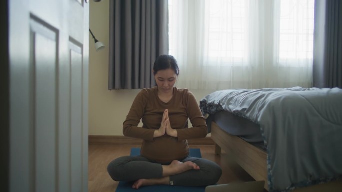 孕妇在家用笔记本电脑在线学习瑜伽