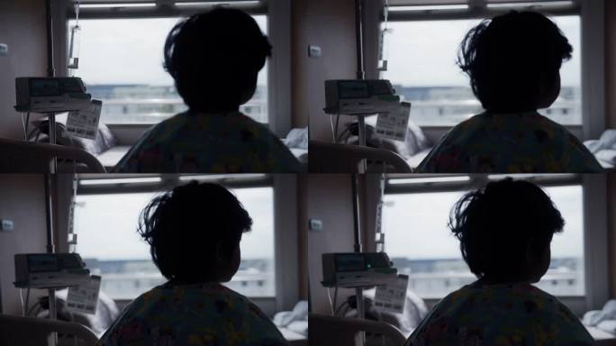 一个患感冒的孩子的剪影望着窗外，住院了。