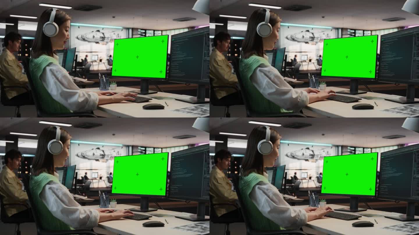 亚洲女性游戏程序员在游戏设计工作室办公室用绿屏Chromakey在台式电脑上编程。专注女性为全新沉浸