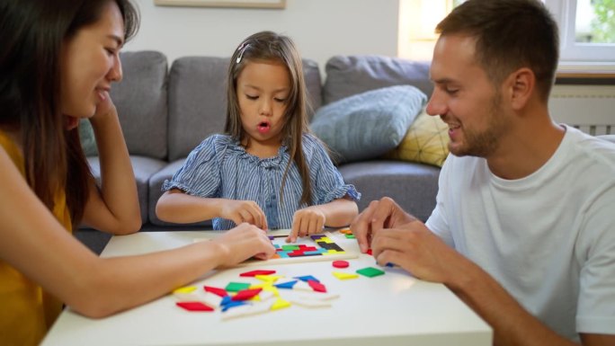 多种族家庭在家里玩拼图游戏