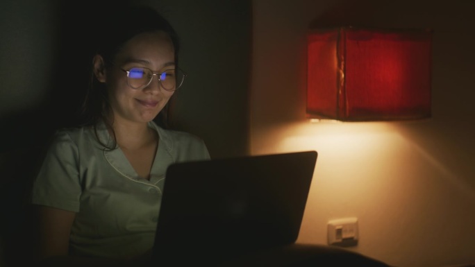 亚洲女人晚上用笔记本电脑