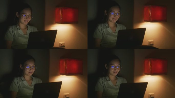 亚洲女人晚上用笔记本电脑