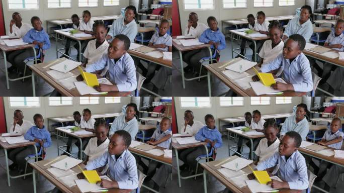 特写镜头。在非洲的一间教室里，一个非洲黑人学生坐在书桌前给全班学生读书