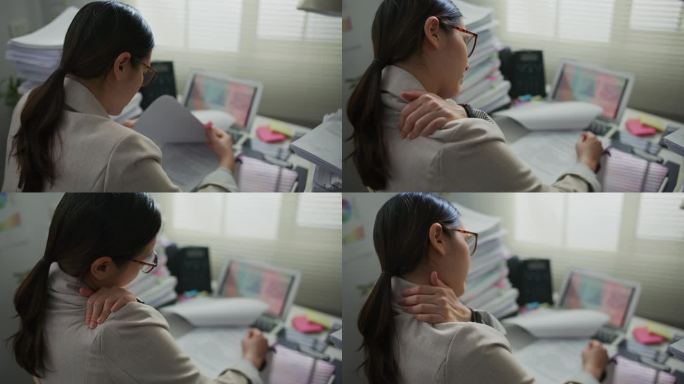 年轻的女商人在现代办公室工作时颈部疼痛