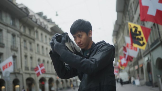 亚洲年轻有才华的男摄影师拍摄照片，拍摄视频，记录城市里人们的生活方式。