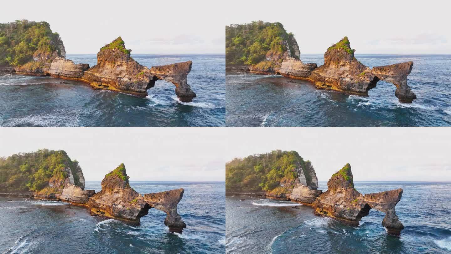 空中无人机日出场景的岩石悬崖在阿图海滩。美丽的大自然努沙Penida在巴厘岛，印度尼西亚。旅游暑假的