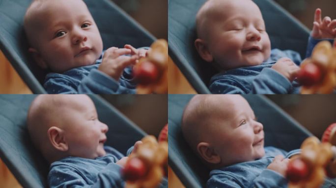 真实的特写镜头，一个可爱的、快乐的、蓝眼睛的新生男孩在镜头前微笑。儿童的概念，天真，幸福，婴儿，为人