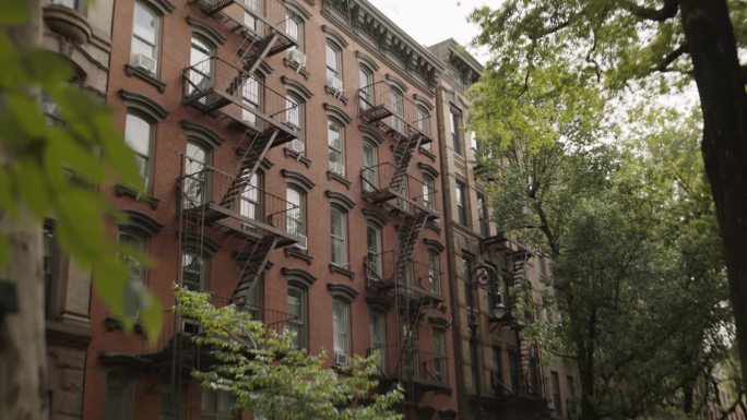 在纽约市重建旧褐石屋拍摄。带紧急楼梯和空调的砖混多层公寓楼日间城市建筑