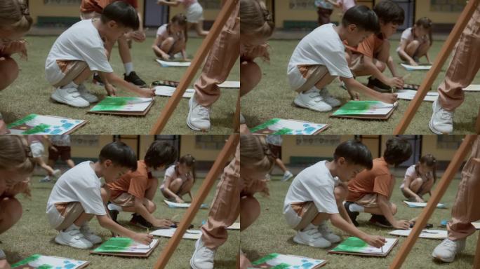 亚洲小学生在学校里和来自不同国家的朋友一起练习在纸上画画。