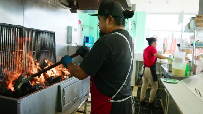 男厨师在墨西哥餐厅烤架上工作