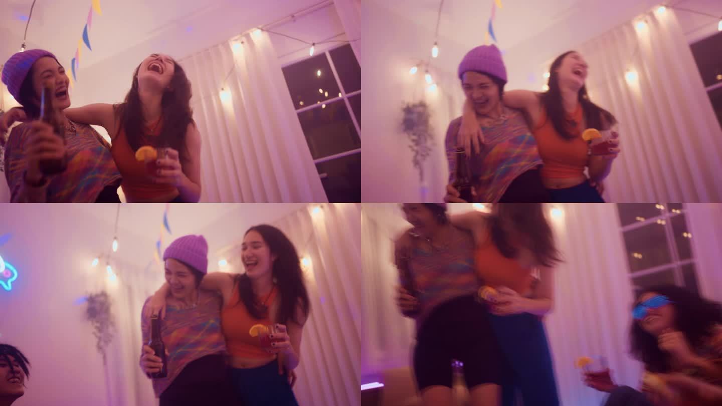 快乐的两个年轻女子与朋友跳舞，享受聚会，庆祝在家里。