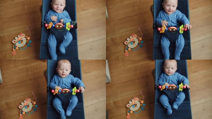 可爱的5个月大的小男孩在蹦床上玩玩具，婴儿活动，孩子在摇椅上玩木制玩具