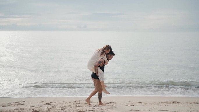 幸福的情侣在爱，浪漫的夏日海滩度假在海水。亚洲男人背美女，猪背骑。